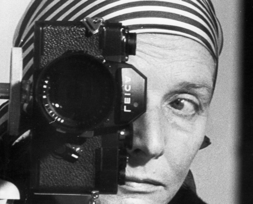 Leonore Mau, Selbstporträt im Spiegel mit Leica und gestreiftem Kopftuch, Hamburg 1980
